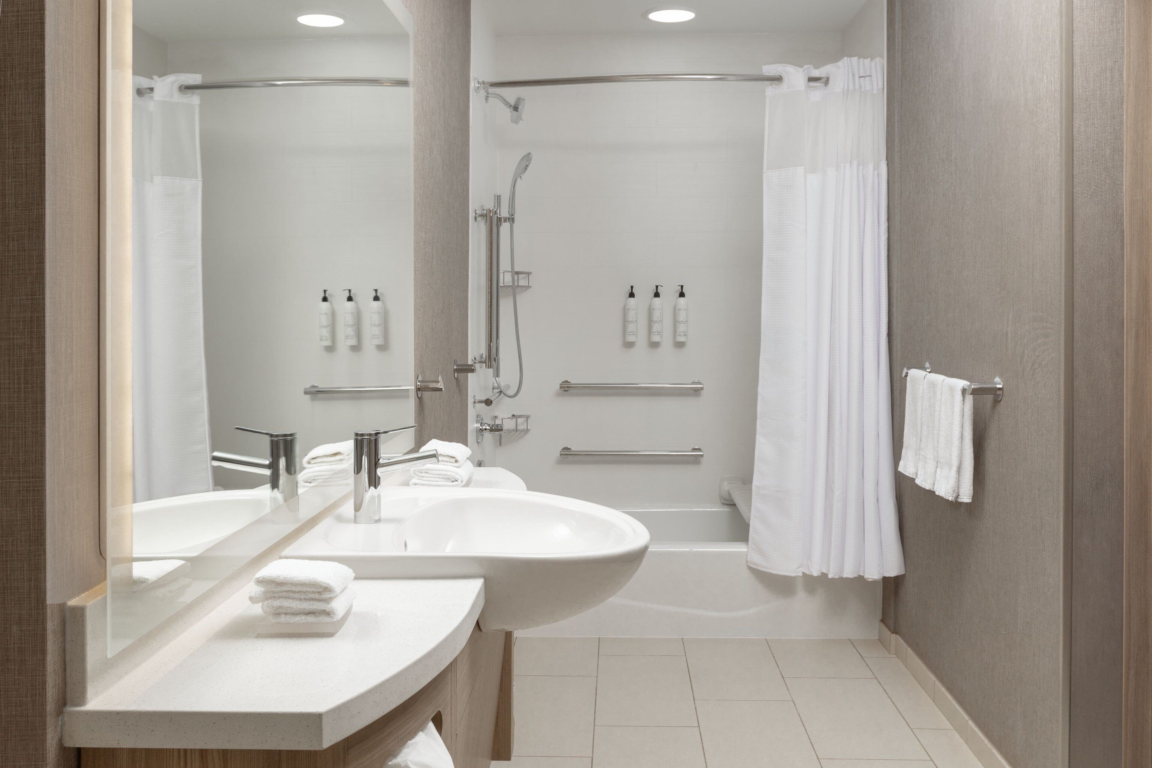 Un baño moderno con lavamanos doble, bañera y ducha.