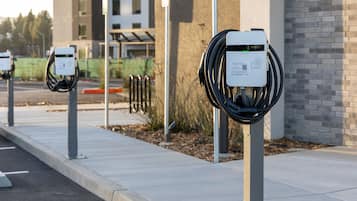 Estaciones de carga para vehículos eléctricos a lo largo de una acera.