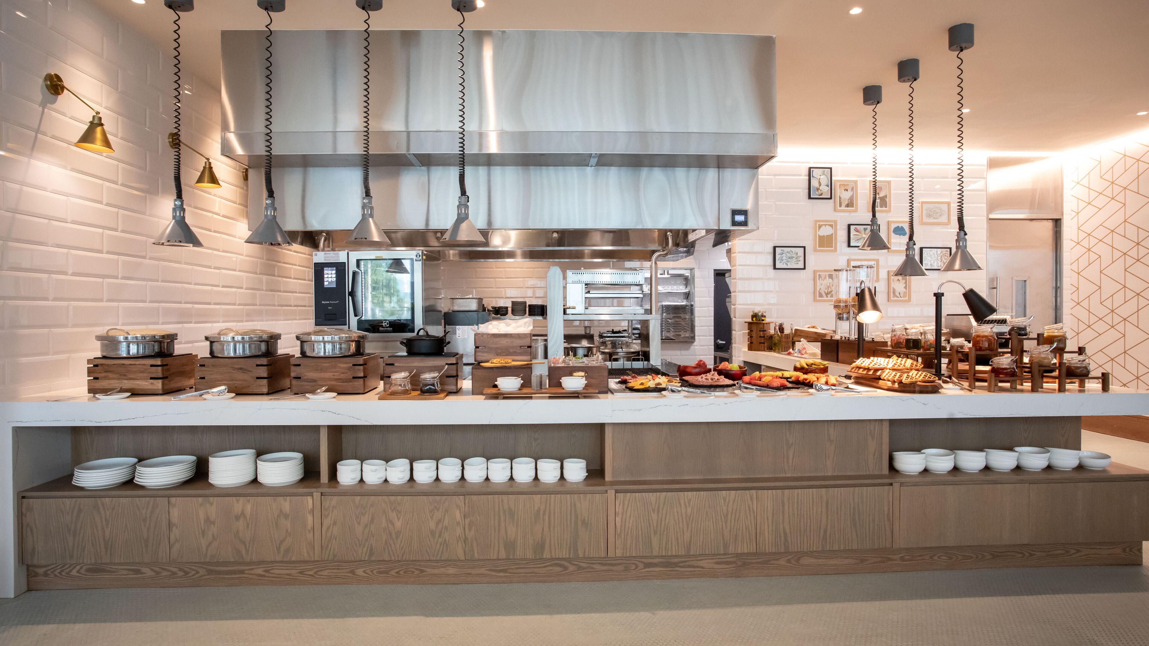 A modern kitchen with stainless steel appliances, wooden cabinets, and a buffet setup.