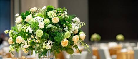 A table set for a formal dining event with a centerpiece of flowers in a clear vase.
