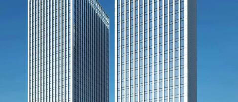 A modern high-rise building with a glass facade and a prominent entrance area.