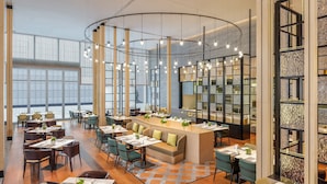 A modern restaurant with a central seating area, high ceilings, and a mix of tables and chairs. - The Westin Wuhan Hanyang (Wuhan)