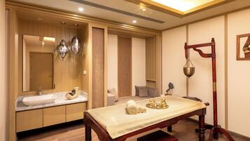 A modern bathroom with a large mirror, a sink, and a vanity. There is a wooden bench with a towel and a scale.