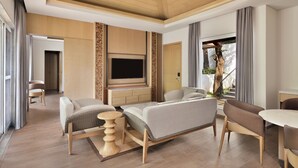 A spacious living area with a large flat-screen TV, comfortable seating, and a wooden ceiling. - Coorg Marriott Resort & Spa (Madikeri)