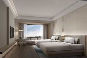 Two large beds with white bedding, a flat-screen TV, and a small table with a chair.