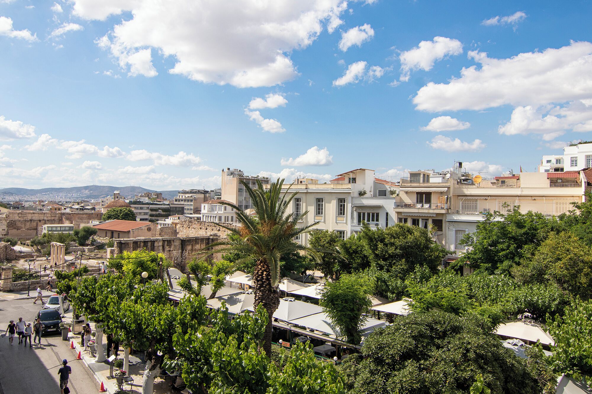 A cityscape with historic buildings, modern structures, and lush greenery.
