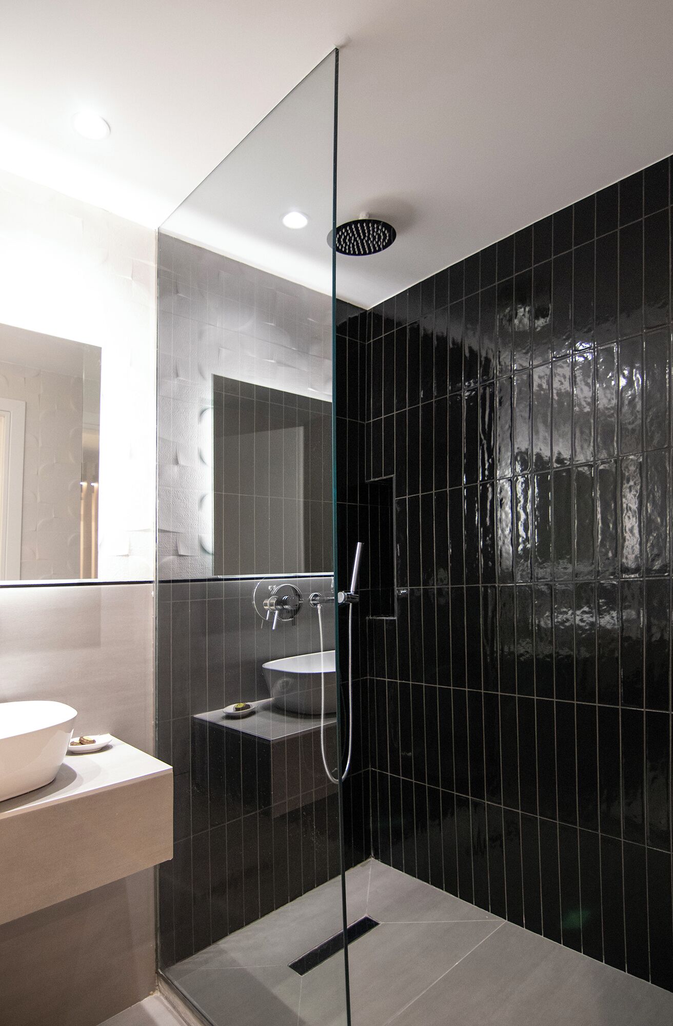 A modern bathroom with a glass-enclosed shower, a sink, and a mirror.