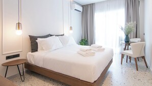A modern hotel room with a large bed, bedside tables, a desk, and a chair. - Mythodea Athens Suites (Athens)