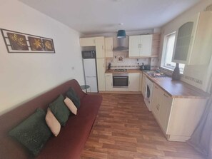 Cozy living space with a kitchenette, sofa, and decorative wall art.