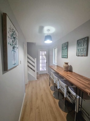 Enjoy cooking in this well-equipped kitchen with a bar area and staircase leading to an upper level.