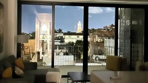 A modern living room with a large sliding glass door leading to a balcony.