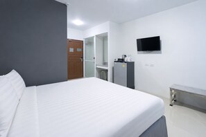 A hotel room with a bed, a desk, a television, and a mirror. - Siam Rama 9 Hotel (Bangkok)