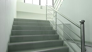 Eine Treppe mit Metallgeländern und einem Schild mit der Nummer 2.