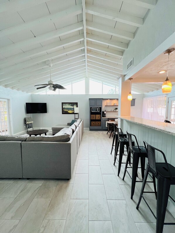 A spacious kitchen with a large island, bar area, and seating.