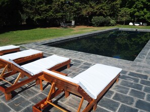A swimming pool with lounge chairs and a stone deck. - Villa Victoria Lodge (Maipu)