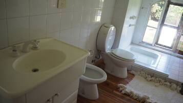 Un baño con lavamanos, inodoro y ventana.