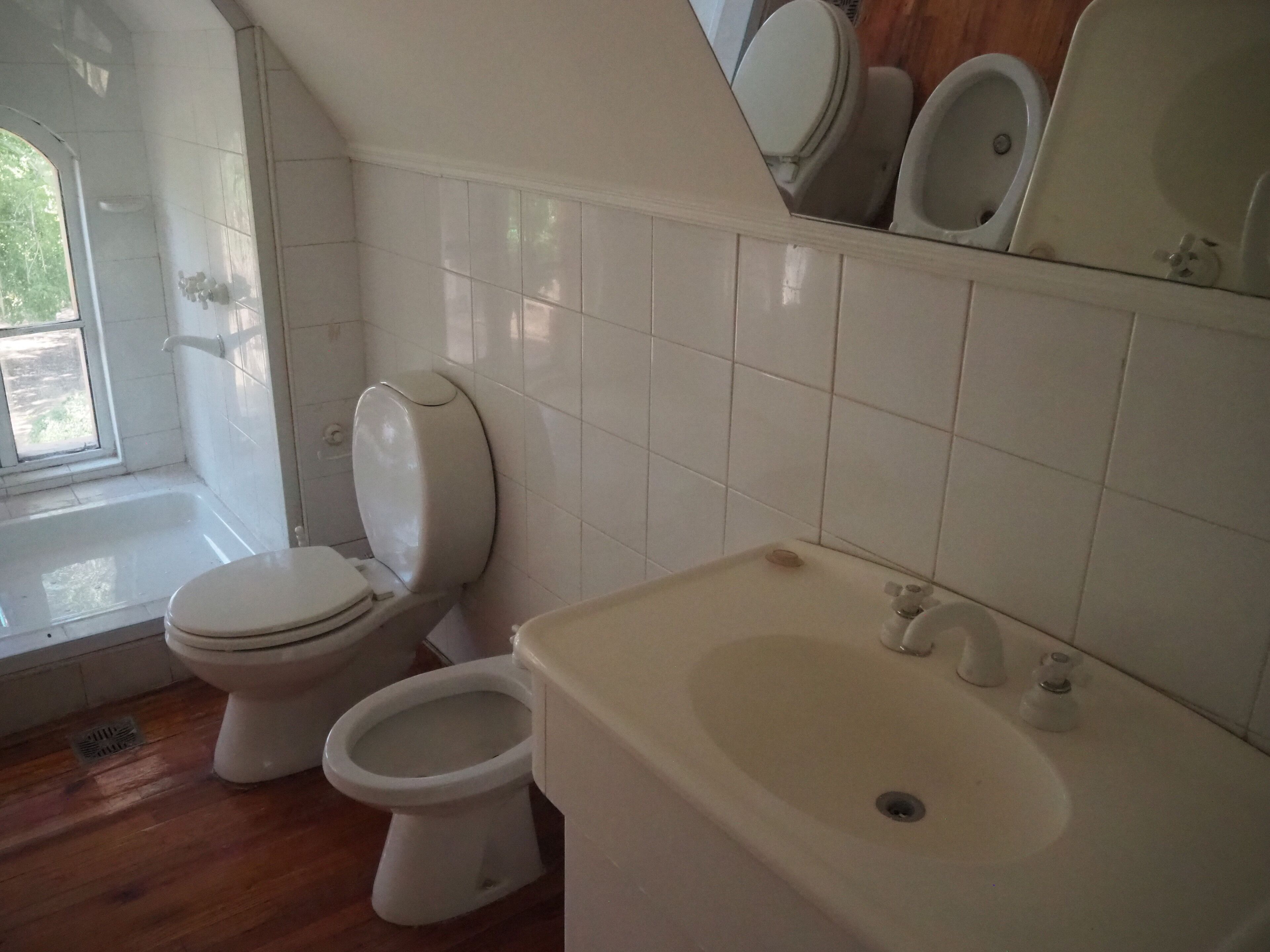 A bathroom with a toilet, bidet, and sink.