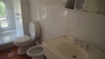 A bathroom with a toilet, bidet, and sink.