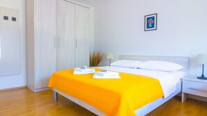 Une chambre à coucher avec un lit, une table de chevet, une lampe, une armoire et un tableau encadré au mur.
