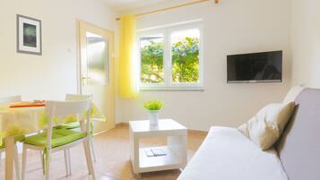 Apartment, Gartenblick | Wohnbereich | 32-Zoll-LCD-Fernseher mit Satellitenempfang