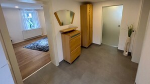 A modern bedroom with a wooden dresser, a mirror, and a small window. - Modern vacation apartment in Altertheim near kist Würzburg highway A3 A81 (Altertheim)