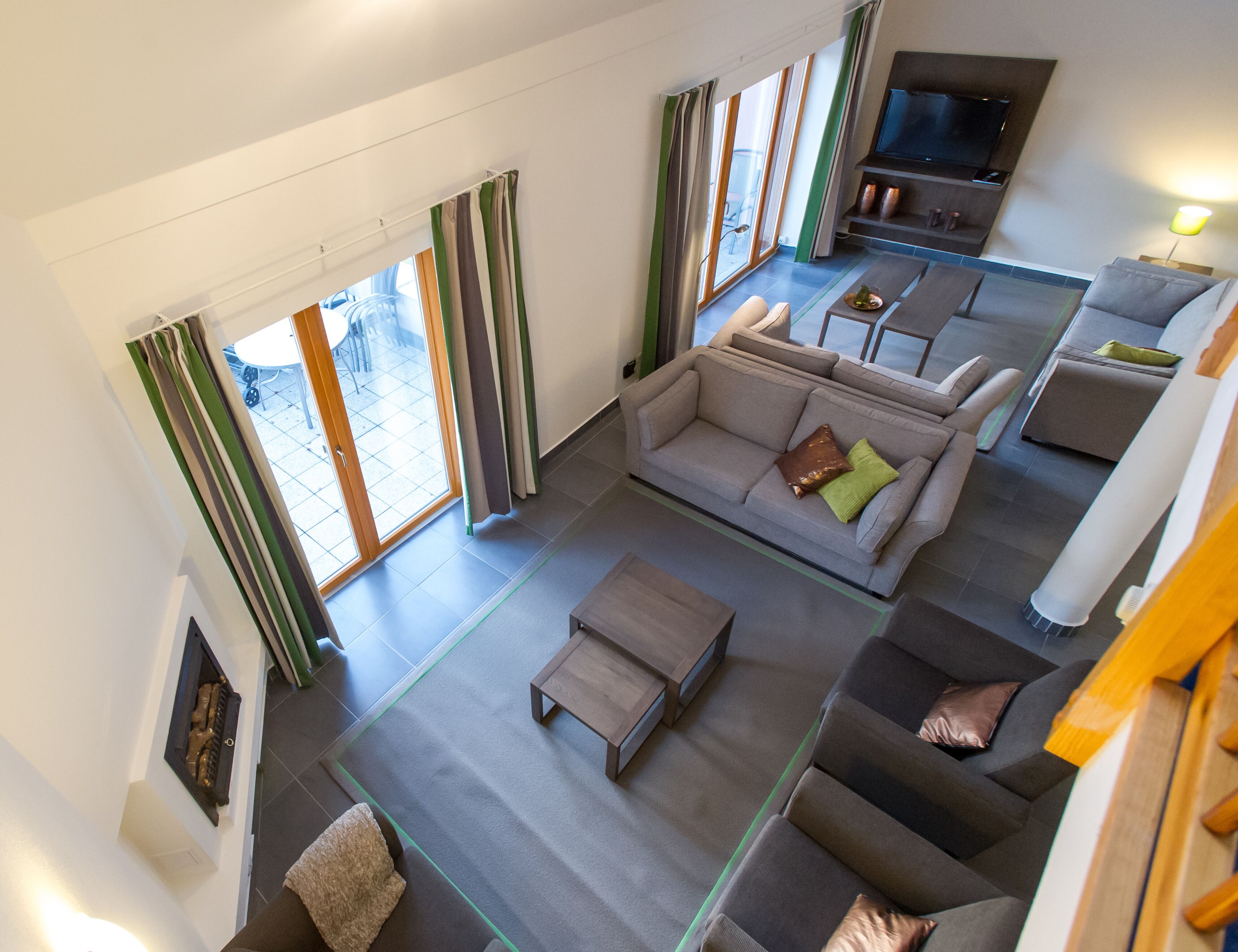 A spacious living area with a sofa, coffee table, and a flat-screen TV.