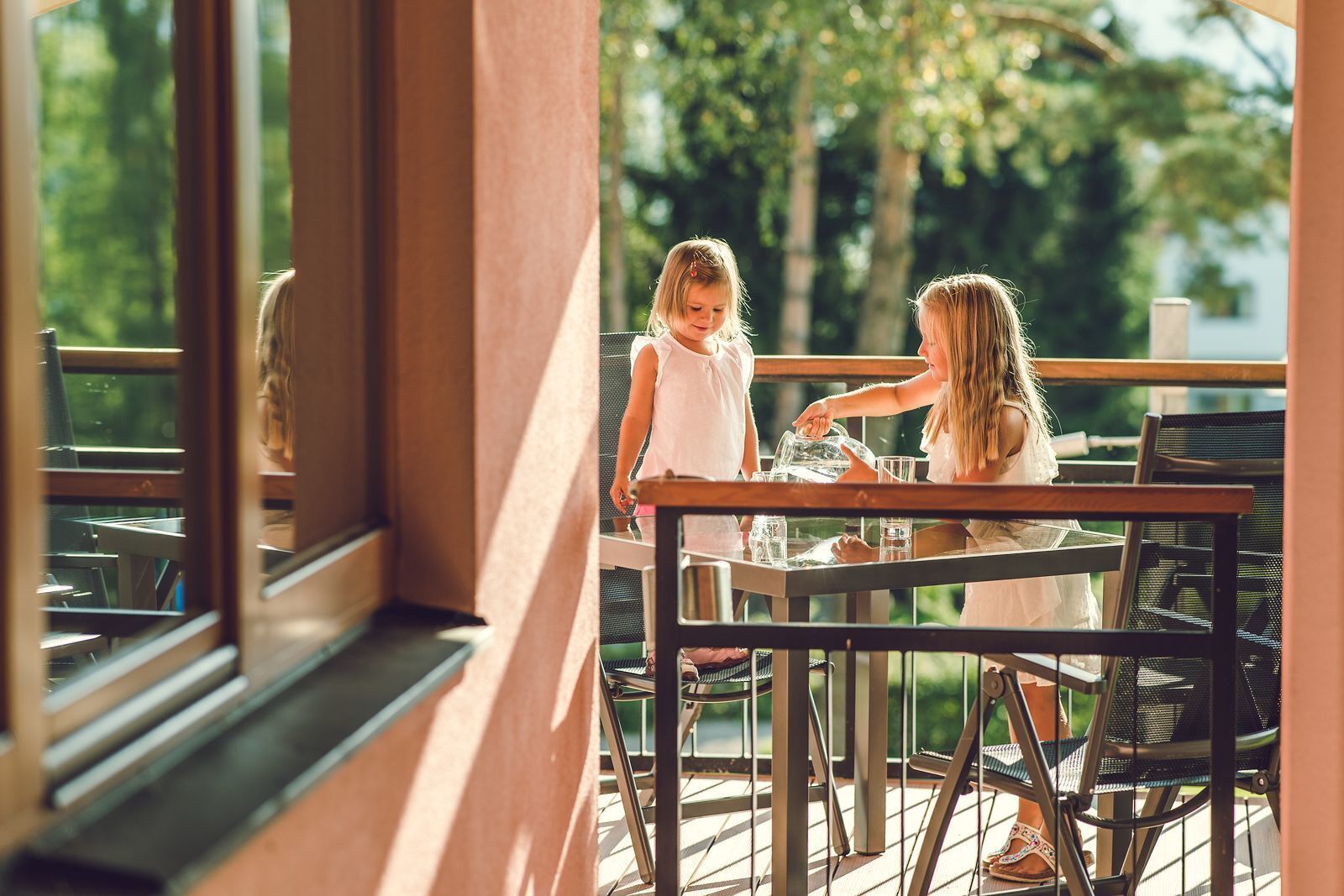 An outdoor patio with tables and chairs, overlooking a natural landscape.