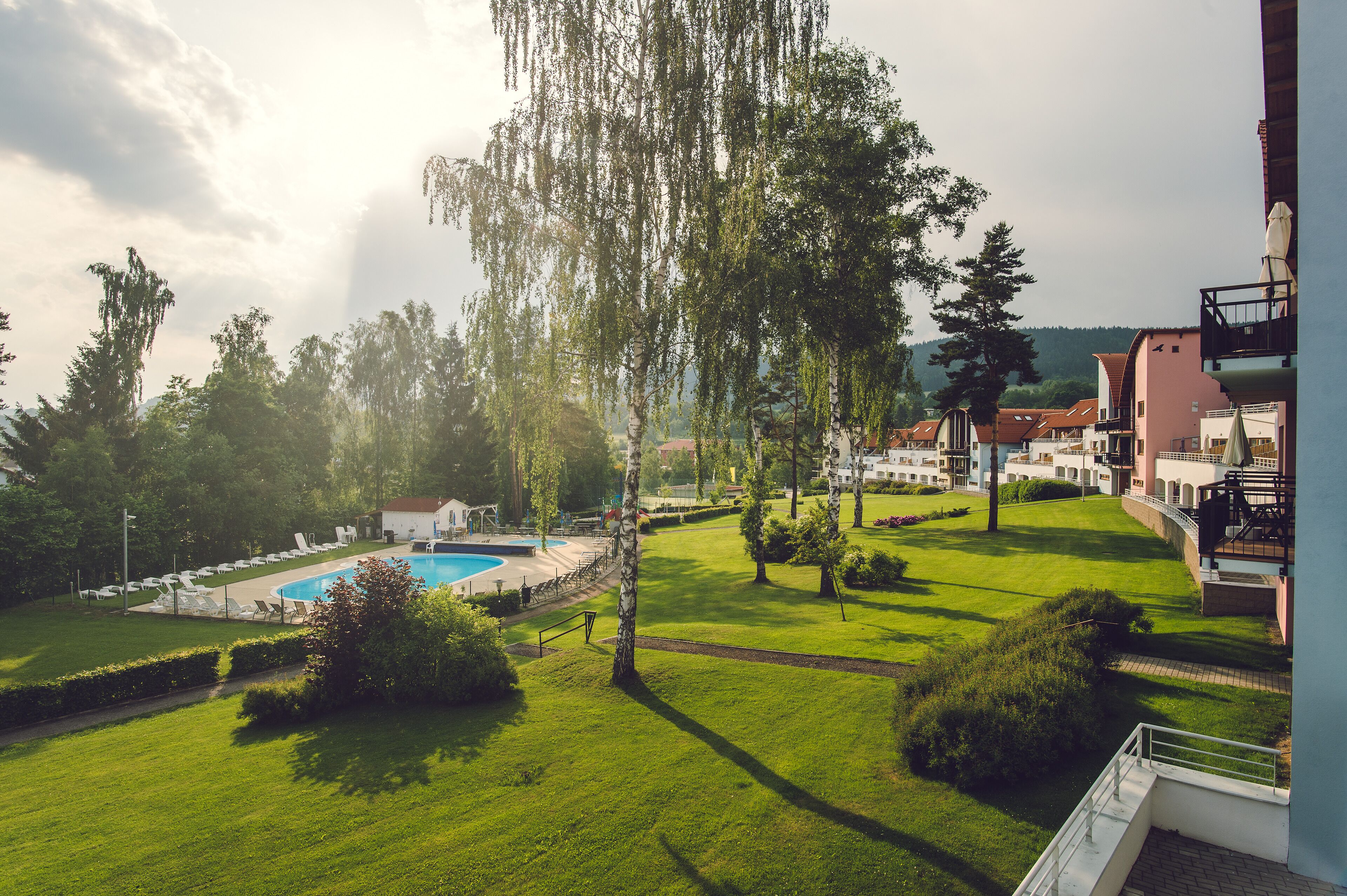 Un quartier résidentiel doté d’une piscine, de pelouses verdoyantes et d’arbres.