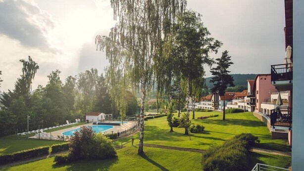 Un quartier résidentiel doté d’une piscine, d’une végétation luxuriante et de maisons avec balcons.