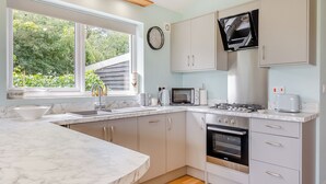 A modern kitchen with a marble countertop, a built-in oven, a microwave, and a gas stove. - An ideal destination for relaxation, comfort and immersion in nature’s beauty. (Old Buckenham)