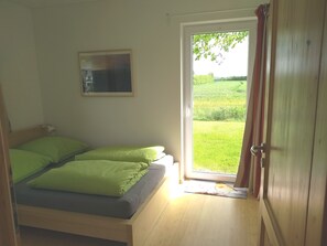 Un dormitorio con cama, ventana y puerta.