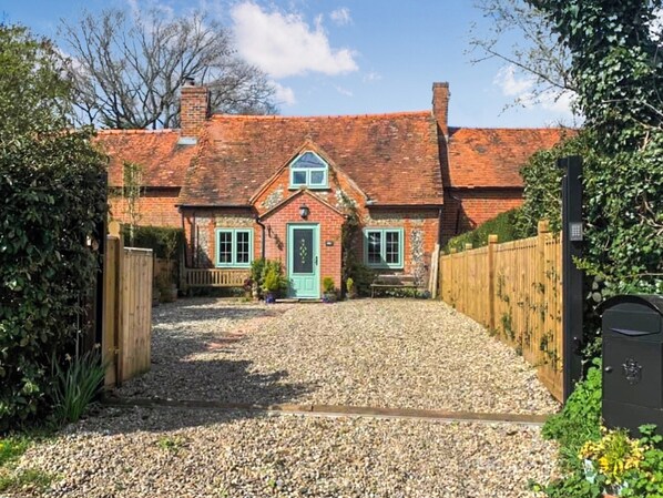 A traditional brick house with a green door, a gravel driveway, and a wooden fence. - 3 bedroom accommodation in Chalkhouse Green, near Reading (Chalkhouse Green, near Reading)