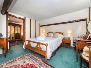 A traditional bedroom with a wooden bed, a nightstand, a dresser, and a mirror. - 3 bedroom accommodation in Chalkhouse Green, near Reading (Chalkhouse Green, near Reading)