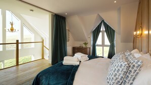 Une chambre avec un grand lit, une commode et une vue sur l’extérieur.