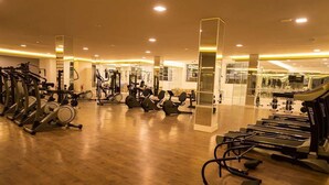 A gym with various exercise equipment, including treadmills, stationary bikes, and weight machines. - Swimming pool apartment. High standard for family or business people! 4 minutes from the subway! (Pinheiros São Paulo)