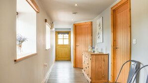 A hallway with wooden doors, a cabinet, and a chair. - The Stables - UK45090 (Longdyke, near Morpeth)