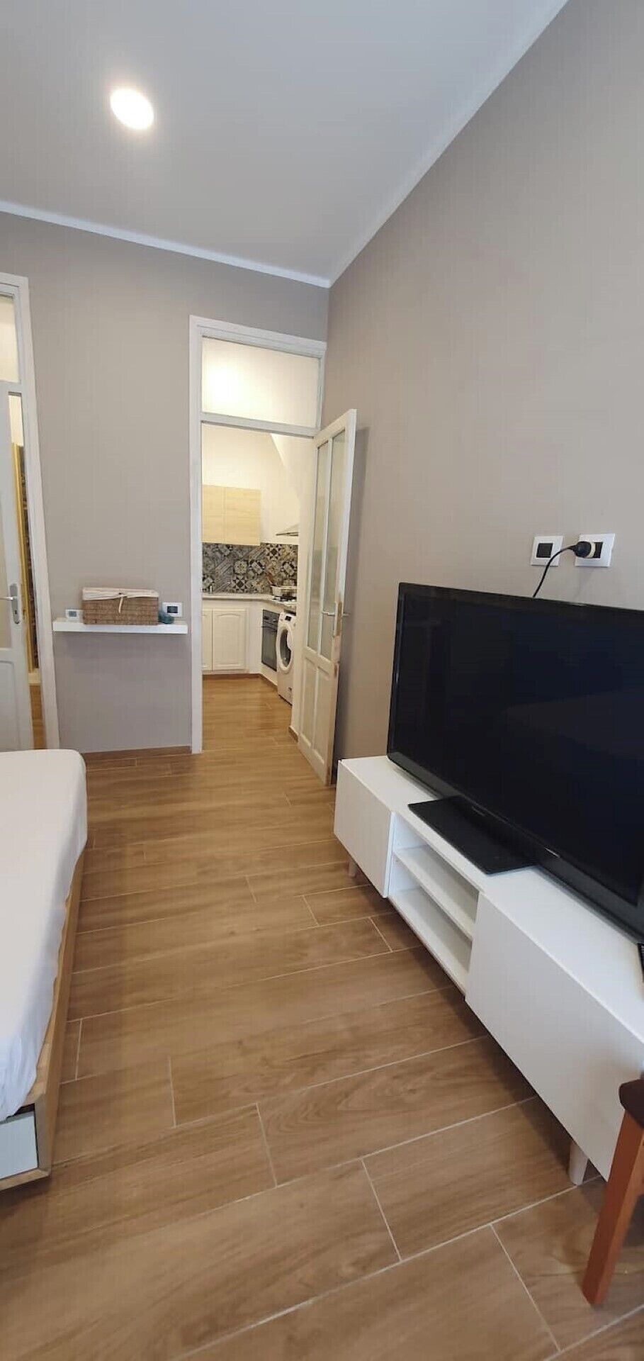 Une chambre d’hôtel équipée d’une télévision, d’un lit, d’une petite kitchenette et d’une salle de bain.
