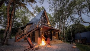 A wooden cabin with a sloped roof, a fire pit, and a deck with chairs. - Thor’s Cabin luxury pet-friendly A-Frame w/ hot/cold tub & sauna 15 min to GSMNP (Cosby)