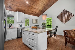 Enjoy meals in the kitchen with a granite countertop and stainless steel appliances, surrounded by lush greenery views.