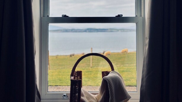 A window with a view of a grassy field and a body of water. - Bracken Cottage - sleeps 4 guests  in 2 bedrooms (Argyll)