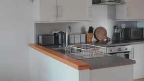 A modern kitchen with white cabinets, stainless steel appliances, and a wooden countertop. - Bracken Cottage - sleeps 4 guests  in 2 bedrooms (Argyll)