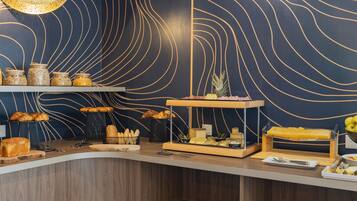 A breakfast buffet with various food items and a decorative wall with wavy lines.