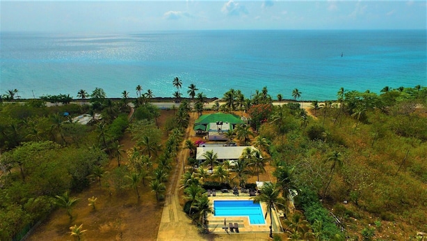 An aerial view of a resort with a swimming pool, palm trees, and a view of the ocean. - Playa Tranquilo B&B  (San Andrés)