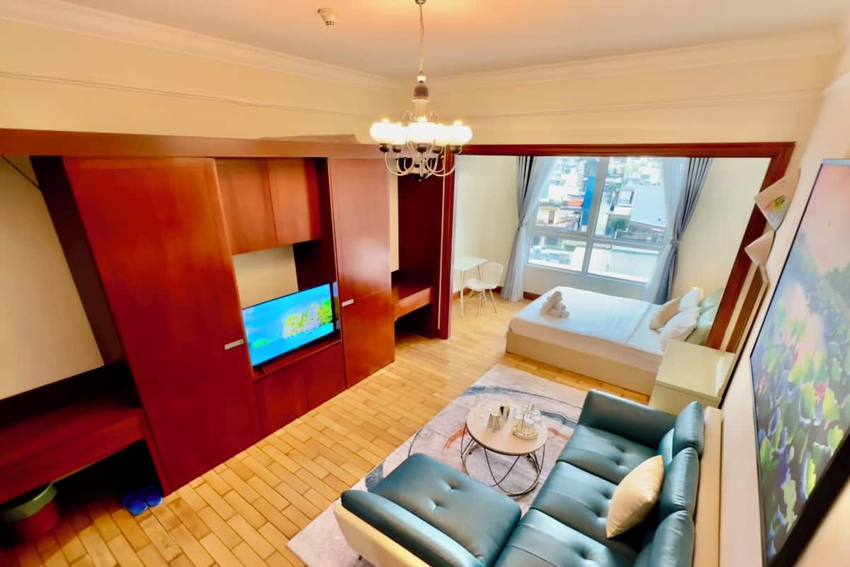 A modern living room with a sofa, TV, and a dining area.