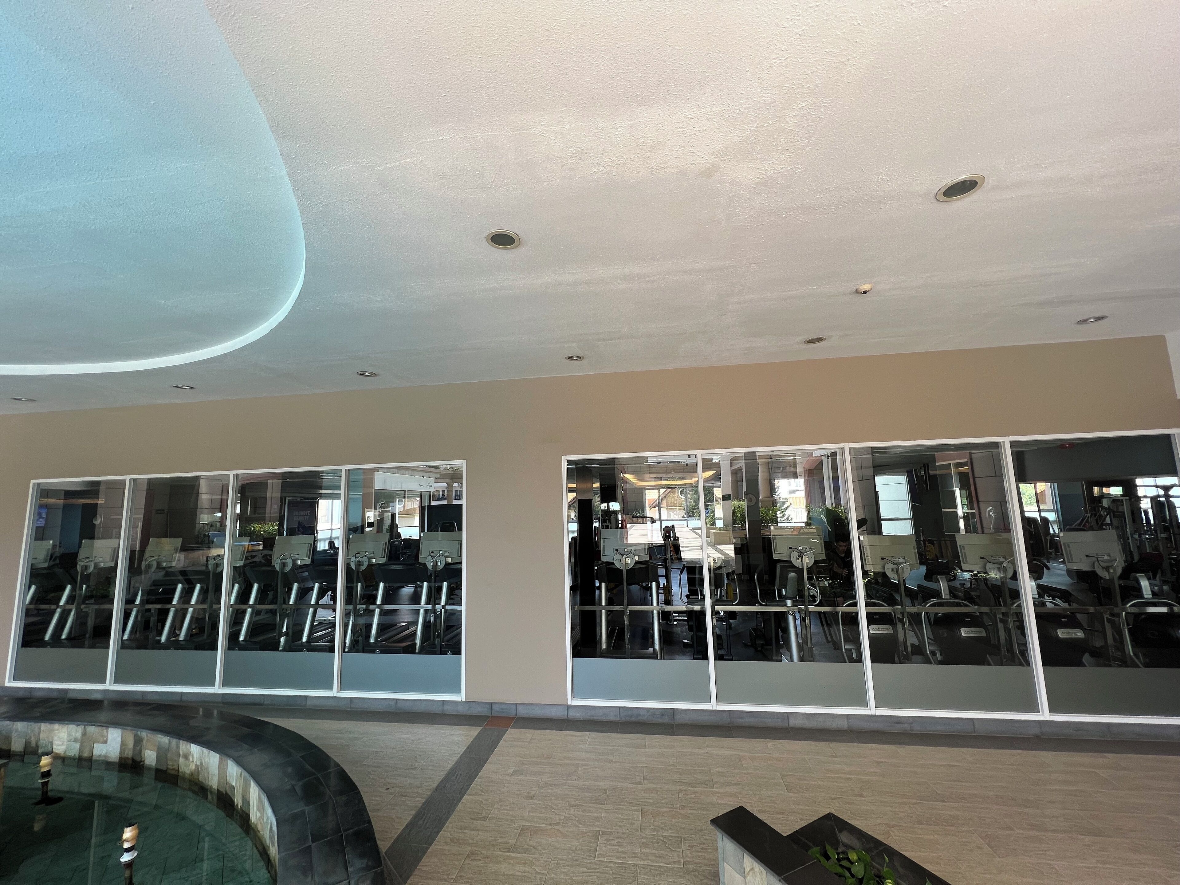 Un gimnasio moderno con paredes de espejo y equipo de ejercicio.