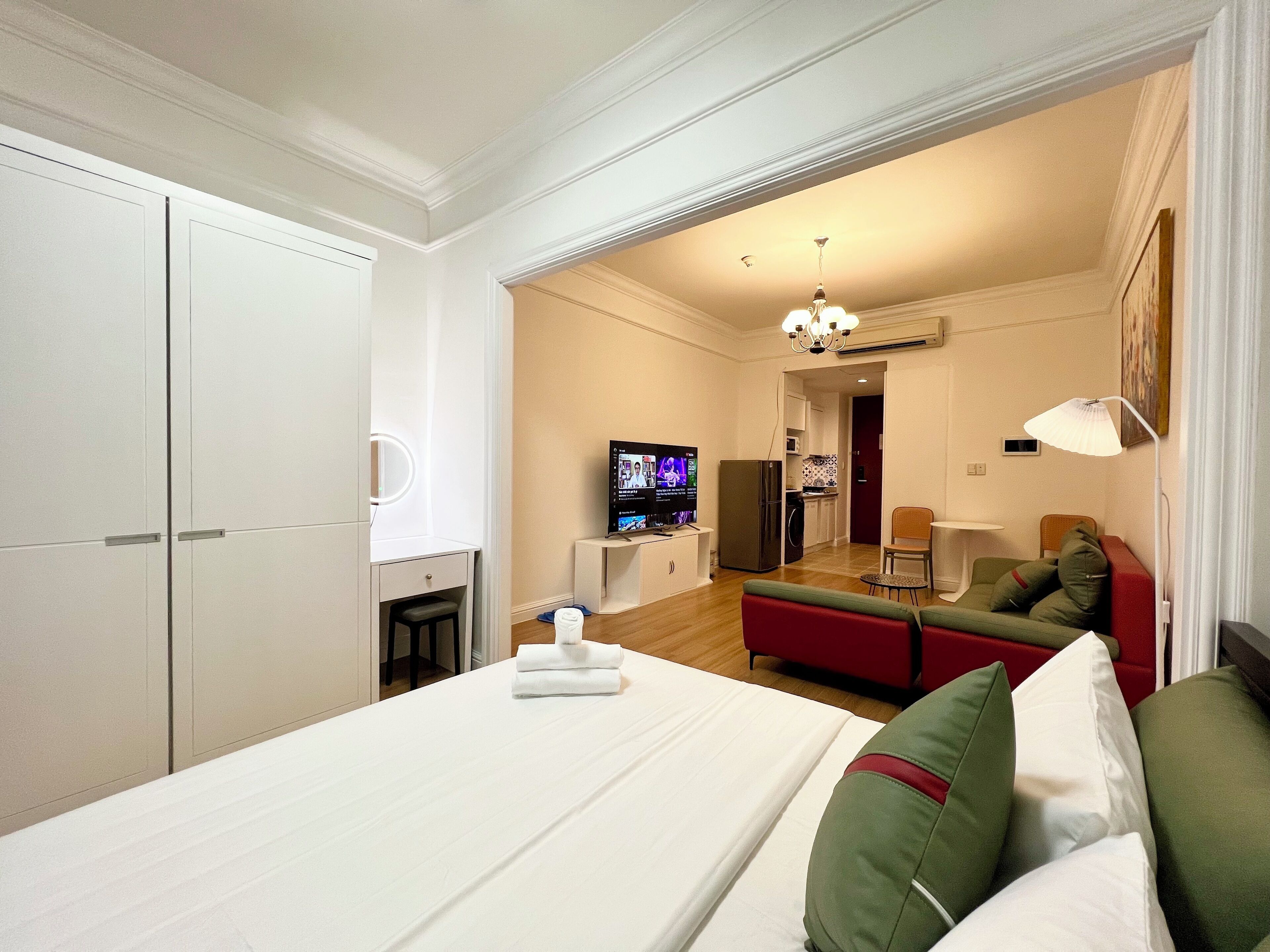 Ein Hotelzimmer mit Bett, Fernseher, einer Küchenzeile und einer Sitzecke.
