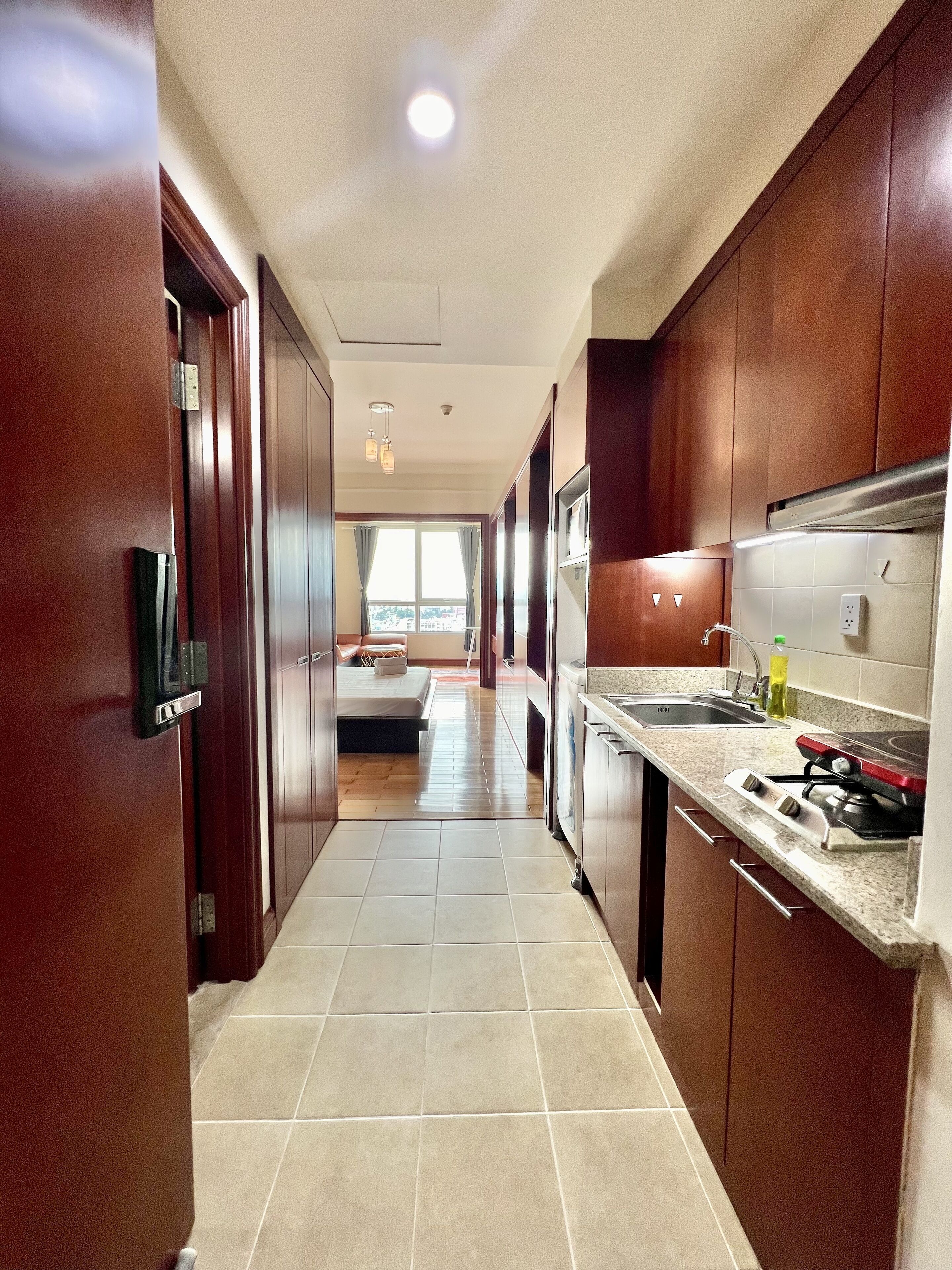 Una cocina moderna con armarios de madera, una campana extractora de acero inoxidable y una encimera de granito.