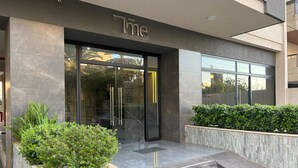 A modern building entrance with a glass door, a sign above the door, and steps leading up to the entrance. - Time22 Apartment Hotel (Amaret Chalhoub)
