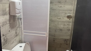Un baño con inodoro, lavamanos y cabina de ducha.