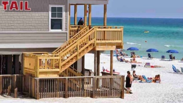 A beachside building with a wooden deck and a lifeguard tower. - Sweet-P*Heated Private Pool (Miramar Beach)